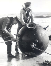 Royal Navy personnel examine an unexploded sea mine